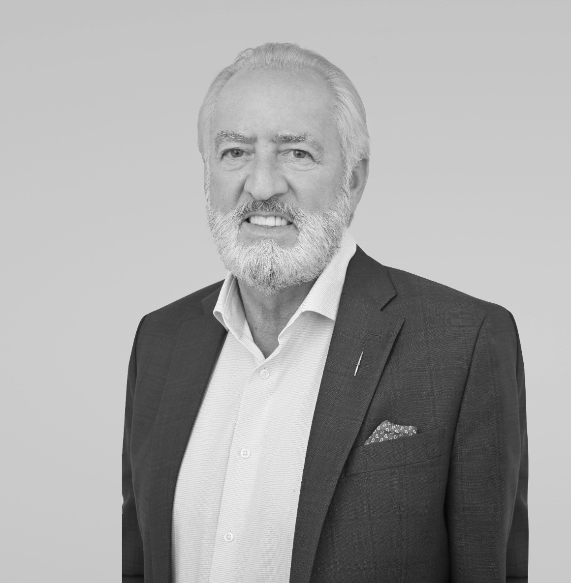 Black and white studio portrait of Ron Kenney in a jacket